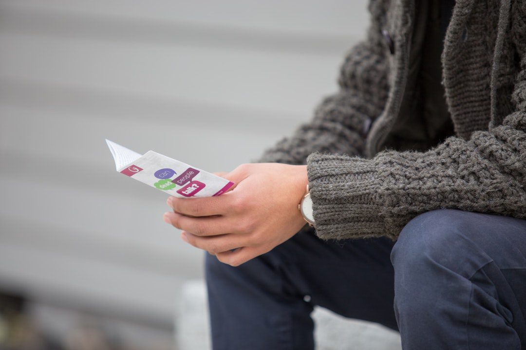 person holding white and multi